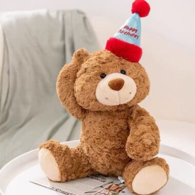 Cute teddy bear plush wearing a colorful birthday hat