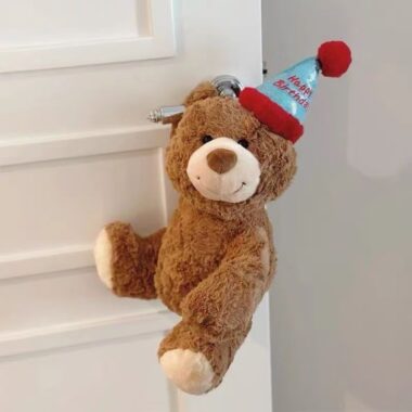 Cute teddy bear plush wearing a colorful birthday hat