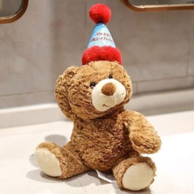 Cute teddy bear plush wearing a colorful birthday hat
