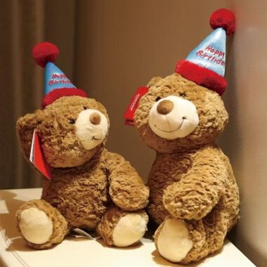 Cute teddy bear plush wearing a colorful birthday hat